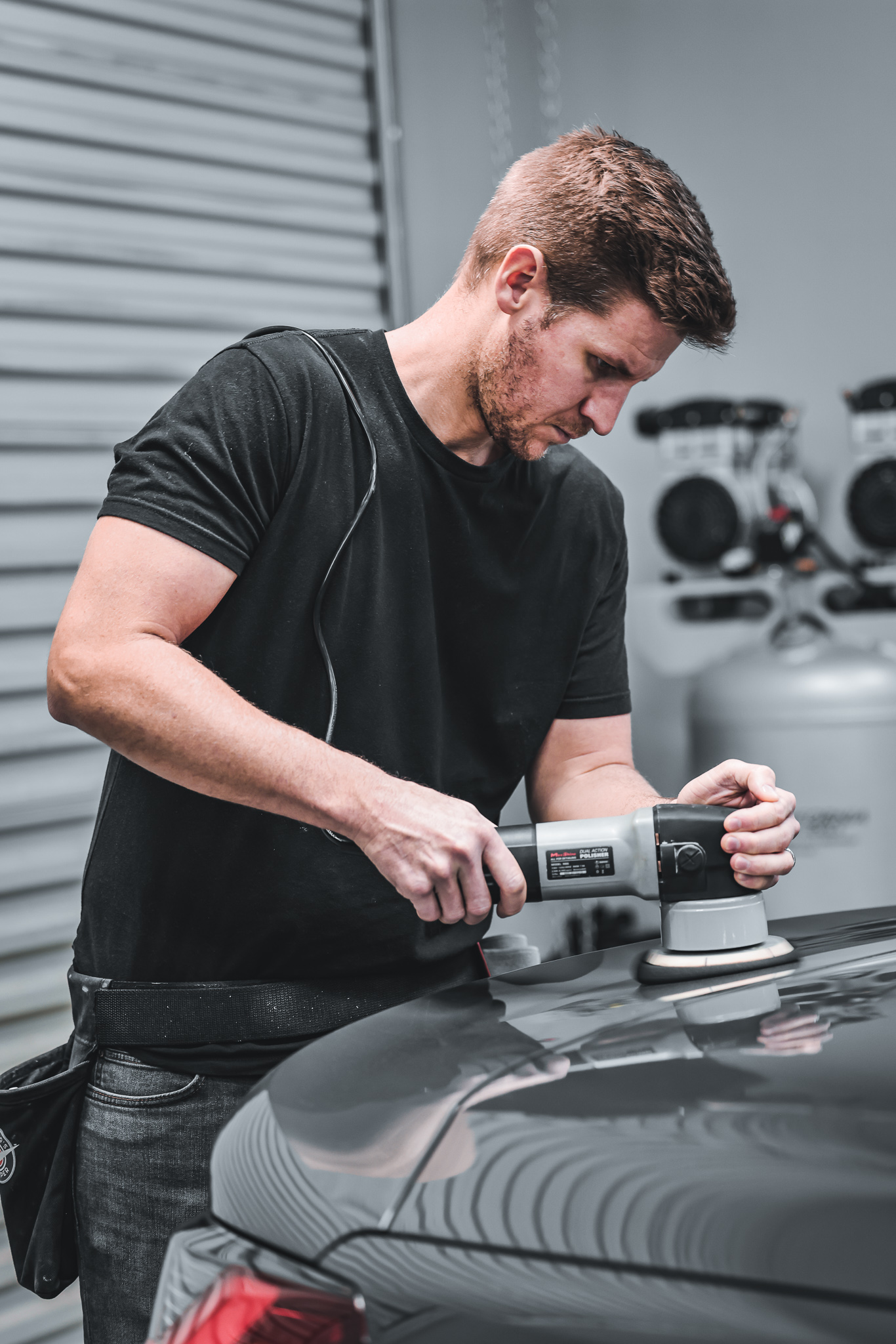 man performing auto detailing with a buffer