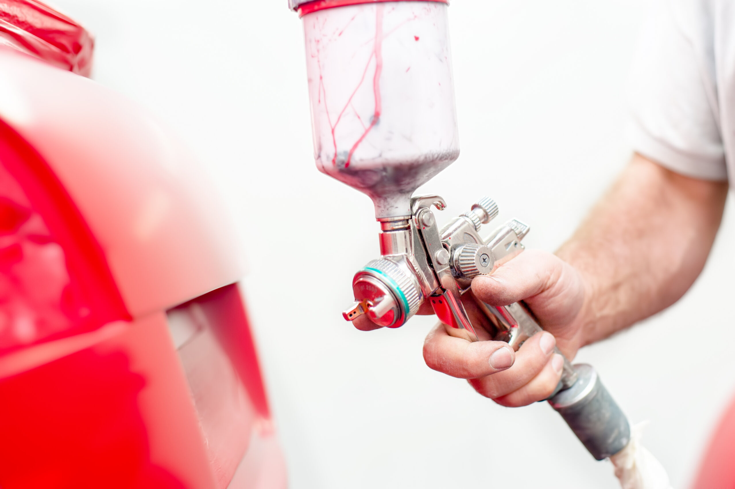 automotive engineer working and painting on body of a car in paint and body shops.