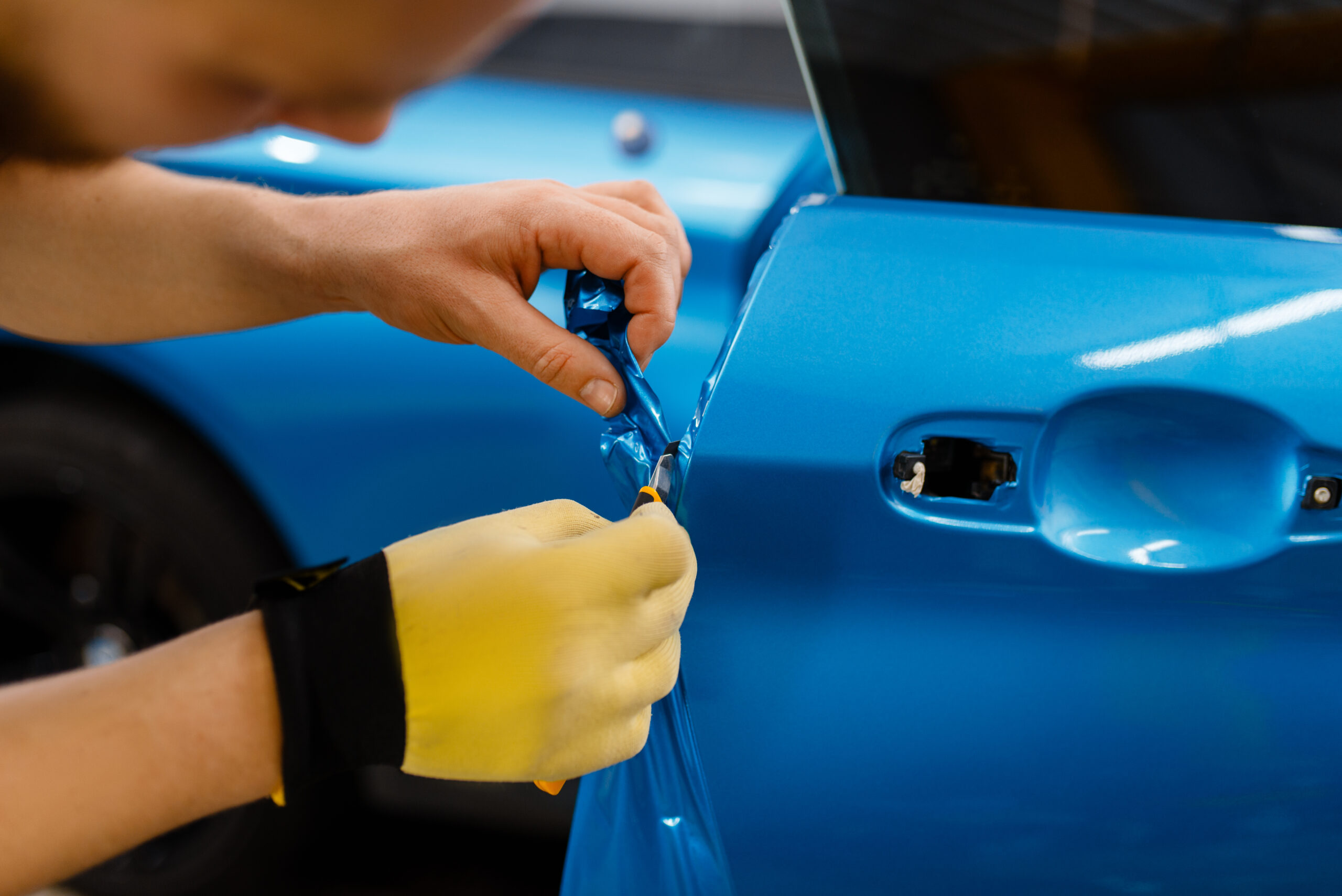 Car wrapper hands installs vinyl foil or film vehicle wrapping.