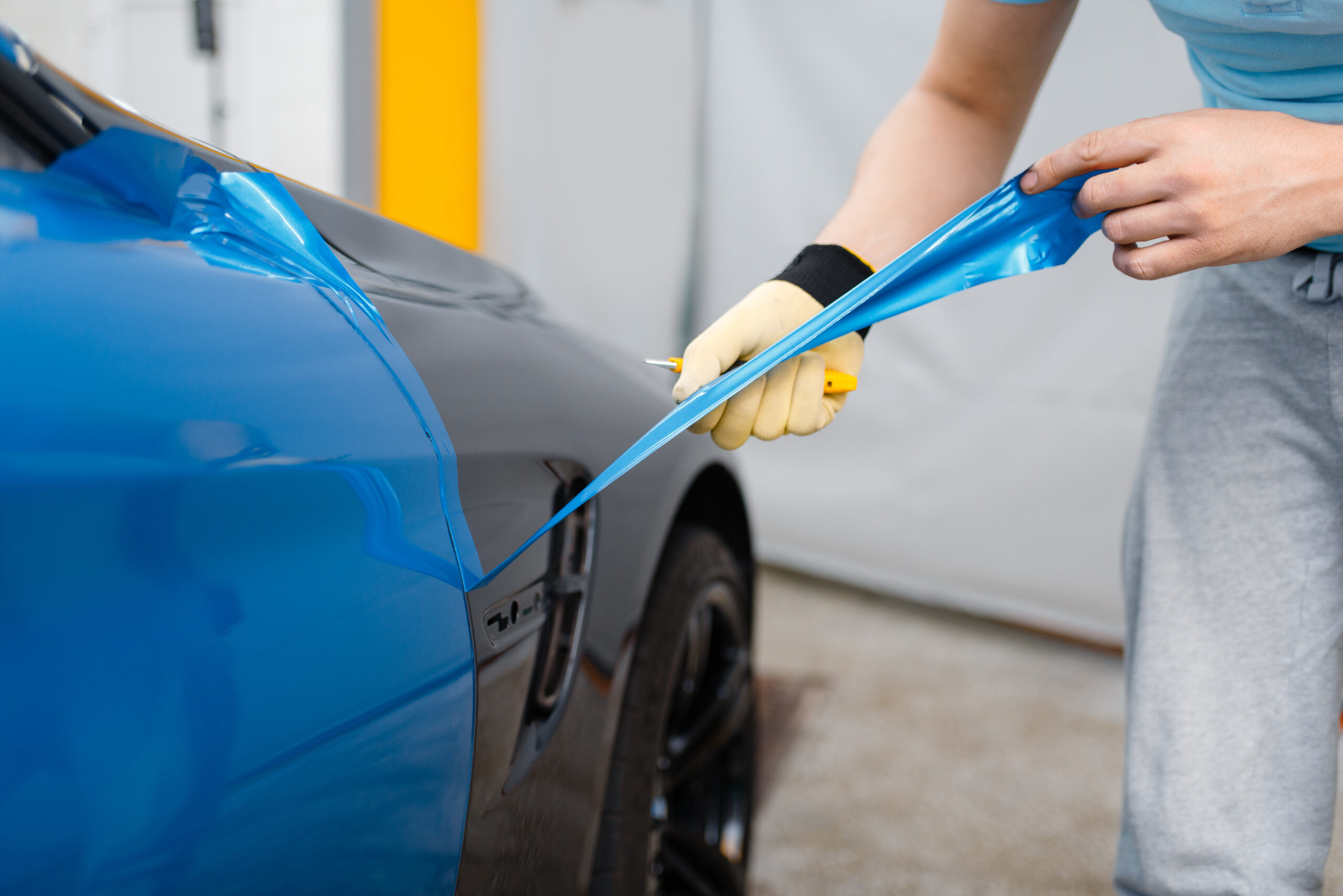 Car wrapper hands installs vinyl foil or film vehicle wrapping.